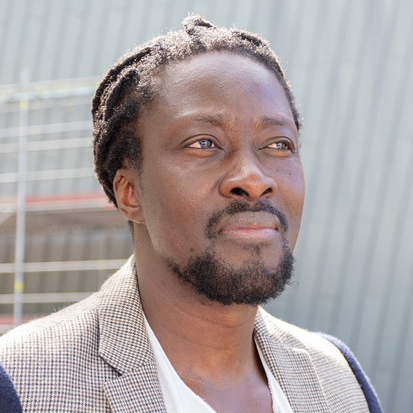 A middle-aged black man with black hair, mushtache, a and short beard.