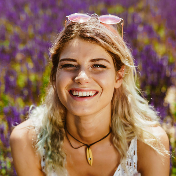 A profile picture of a beautiful blonde woman in her 20s with glasses on top of her head like a headband. She's in a field of lavender.